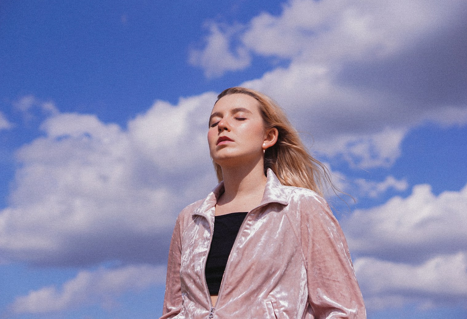 Angela outdoors against a cloudy sky